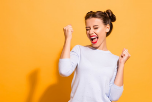 Excited woman raising arms in celebratory pose